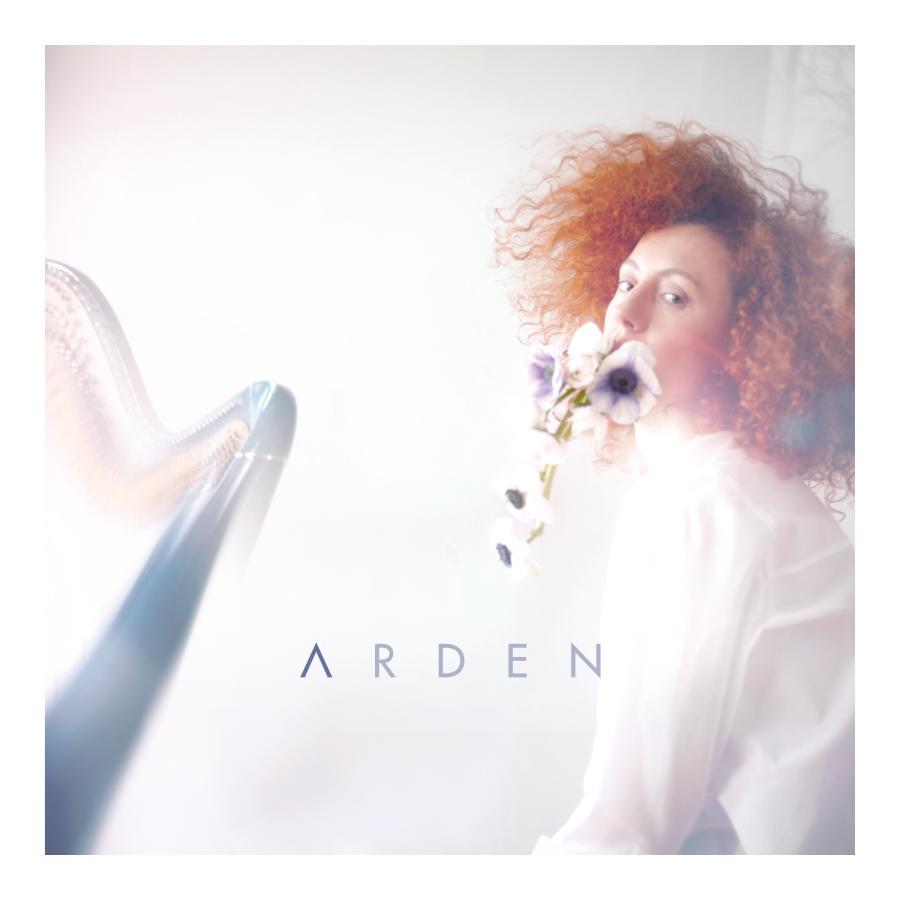 Release-Cover „Arden“ von Arden. Helles, weich überbelichtetes Porträtfoto einer Frau mit rotem lockigem Haar neben einer Harfe und weißen Blumen; warme Pastelltöne, seitliche Perspektive und luftige, verträumte Lichtstimmung.